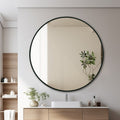 Round mirror with black frame in a modern bathroom setting