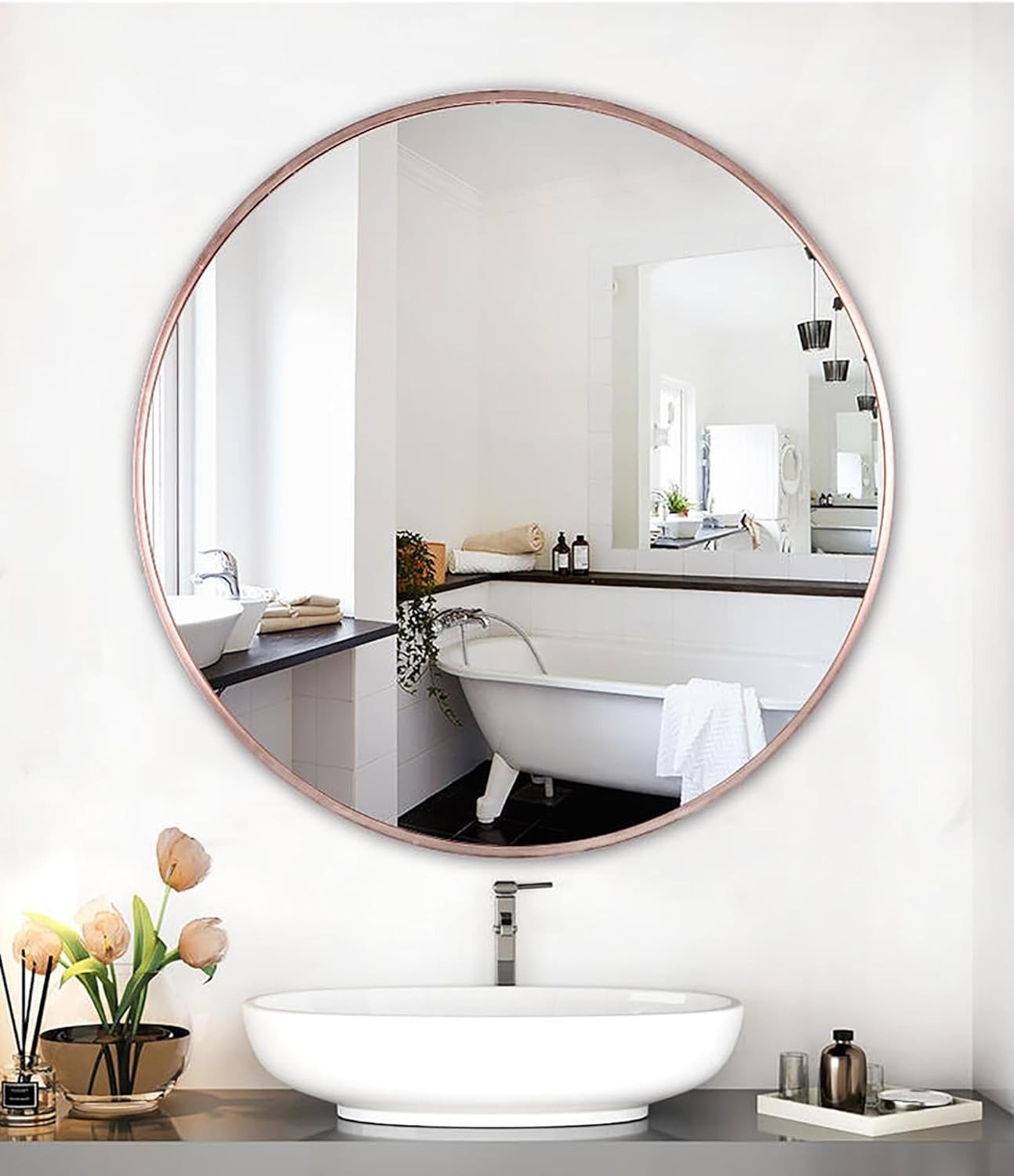 Round mirror with rose gold frame in a bathroom setting